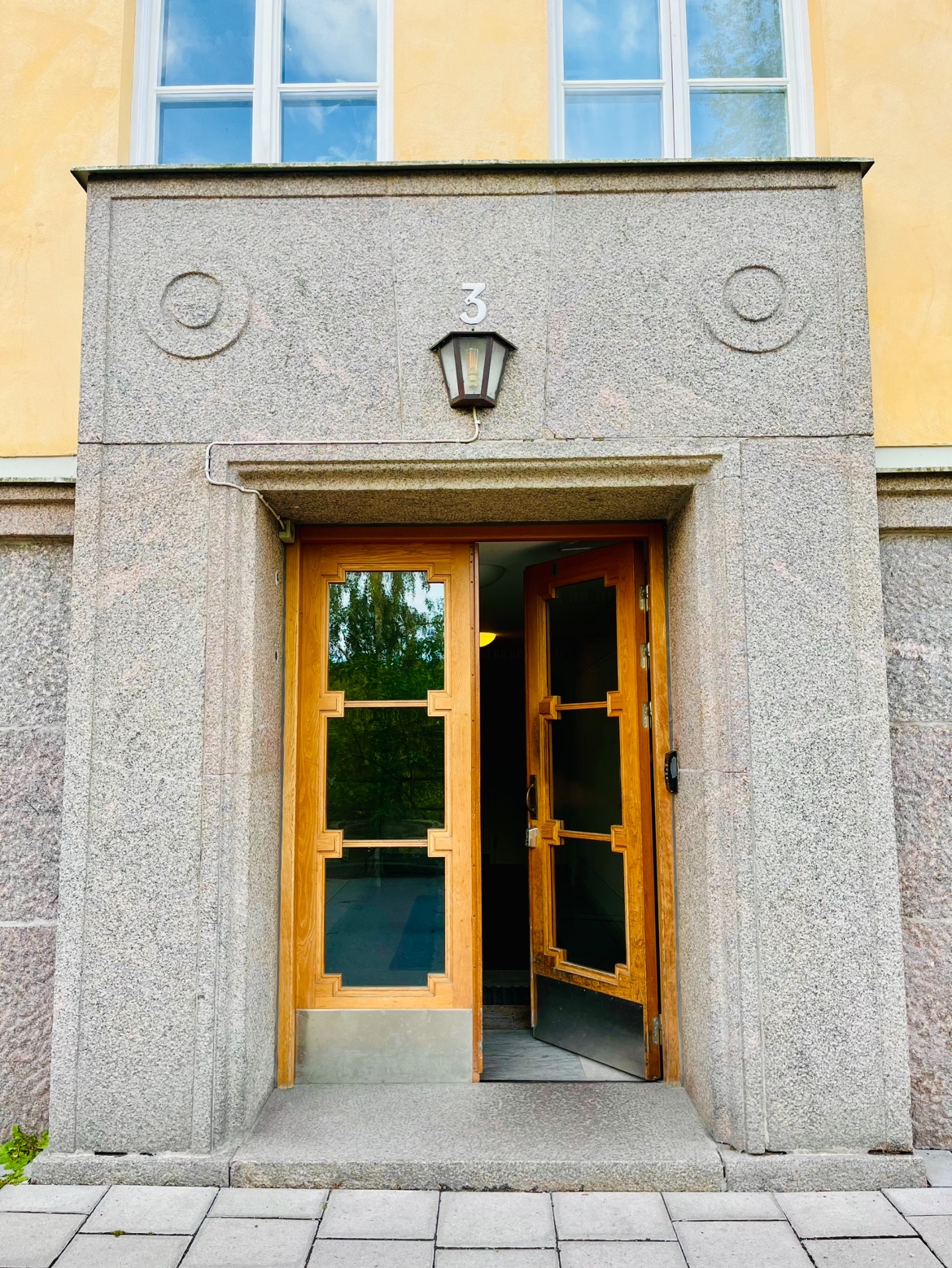Entré till bostadsrättsföreningen Brf Huggjärnet 21 på Lorensbergsgatan 3 med originaldörr i trä.