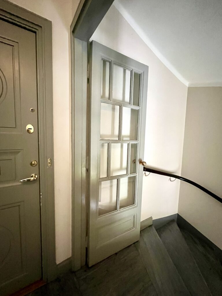 Målad innerdörr med glaspartier i trapphuset på Lorensbergsgatan 3.